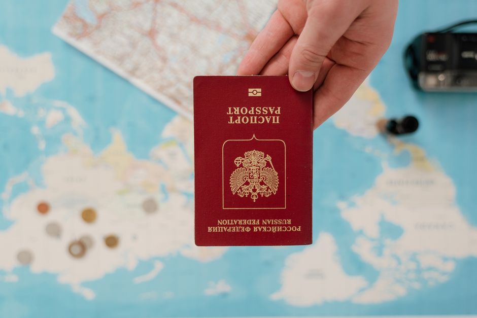 A hand holding a Russian passport over a map, suggesting travel preparation, Huizhou, Guangdong