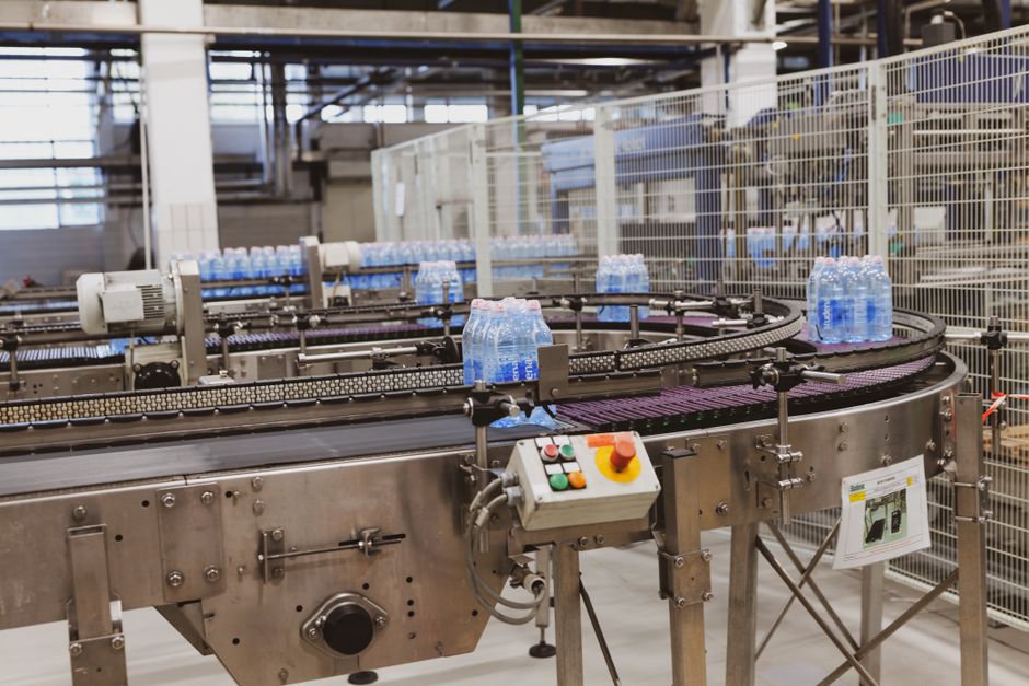 Water bottles being processed on an automated conveyor in a modern factory setting, Huizhou, Guangdong