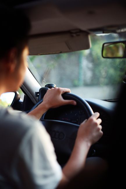 Close-up of a person driving an Audi car showcasing hands on the steering wheel and dashboard view, Huizhou, Guangdong