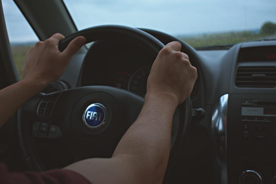 Close-up of hands on the steering wheel of a Fiat car interior, perfect for travel and automotive themes, Huizhou,...