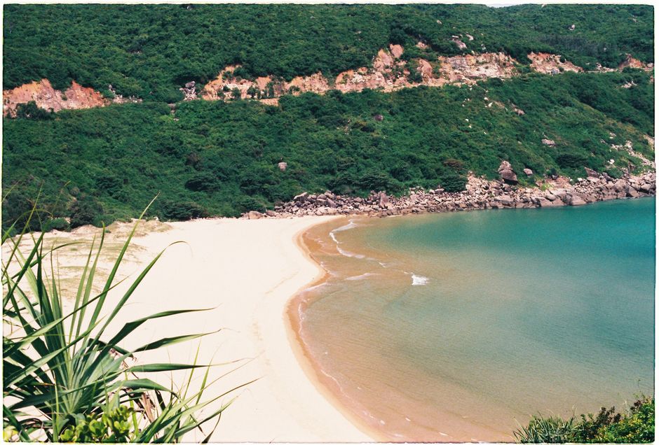 A stunning tropical beach cove with golden sand, turquoise waters, and lush green cliffs, Huizhou, Guangdong