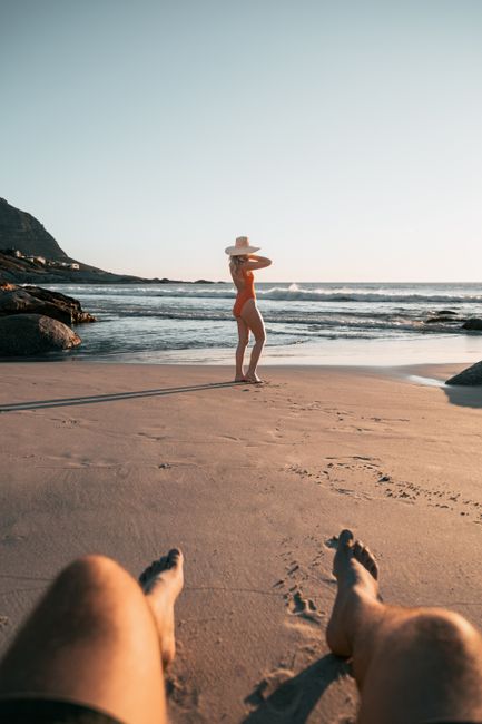 A relaxing beach scene with a woman in swimwear and a hat by the ocean, Huizhou, Guangdong