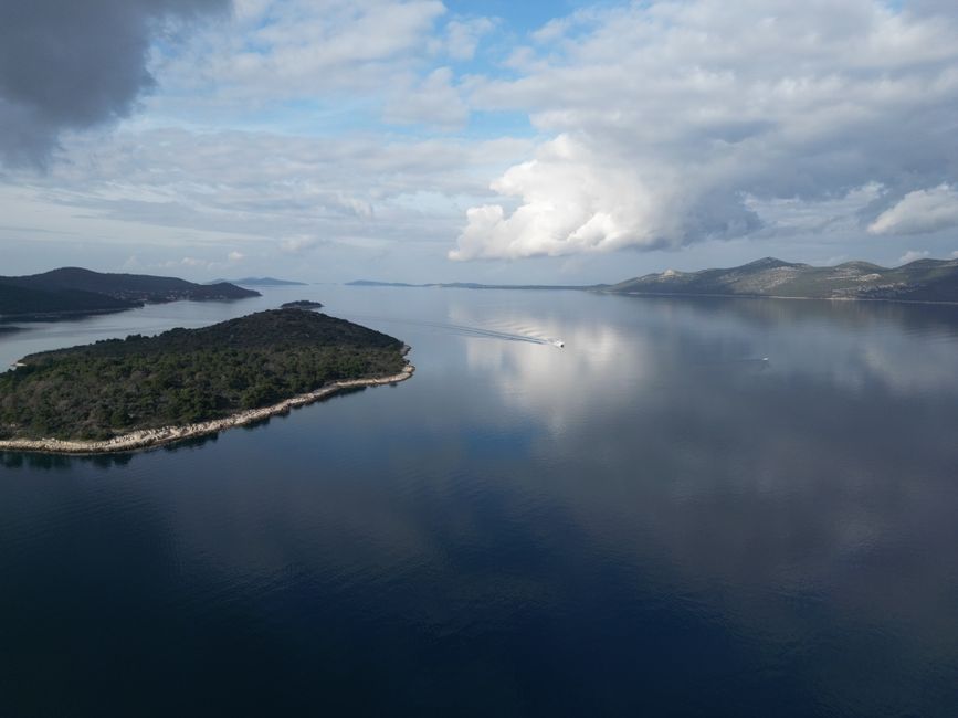 Serene aerial shot of Mali Iž island reflecting on the Adriatic Sea with a cloudy sky, Huizhou, Guangdong