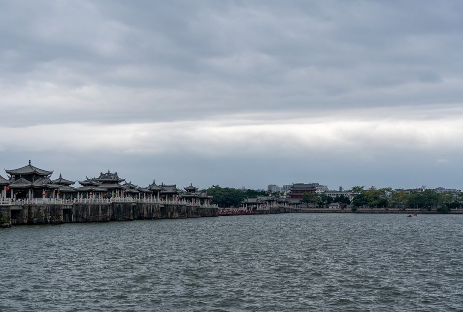 Scenic view of ancient bridge under cloudy skies over waterfront, showcasing traditional architecture. — Huizhou,