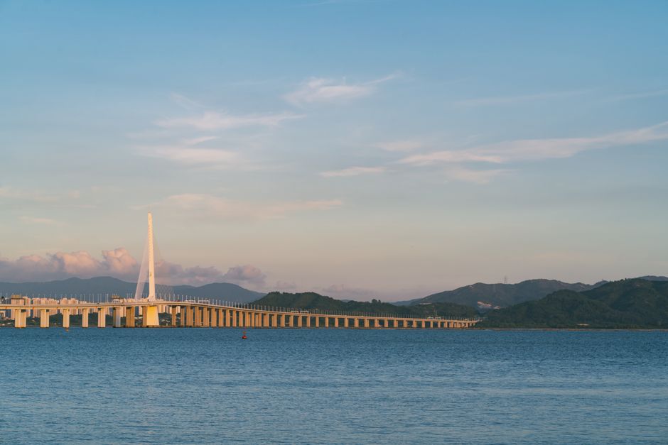 Tranquil scene of Shenzhen Bay Bridge against a serene sunset backdrop over calm waters. — Huizhou, Guangdong, China