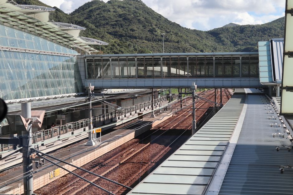 Contemporary railway station in Hong Kong set against lush mountains, showcasing modern architecture. — Huizhou, Guangdong, China