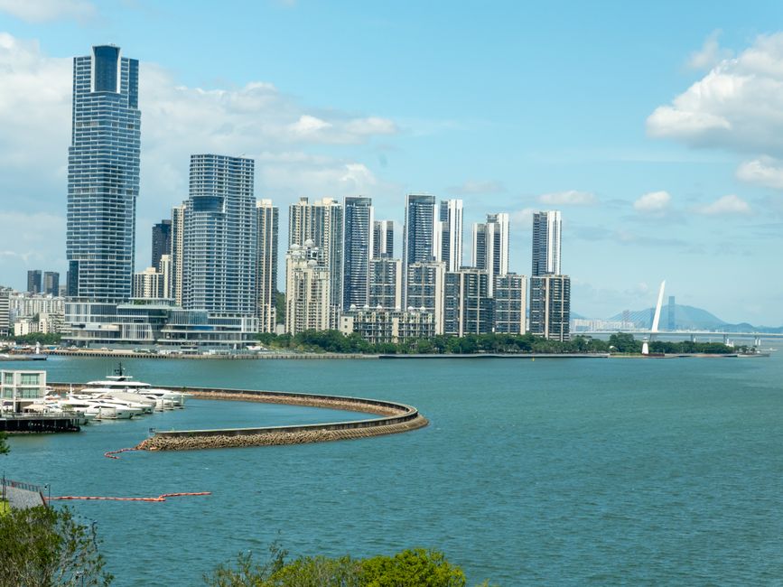 Captivating view of Shenzhen skyline with towering skyscrapers along the waterfront under a bright blue sky. — Huizhou,