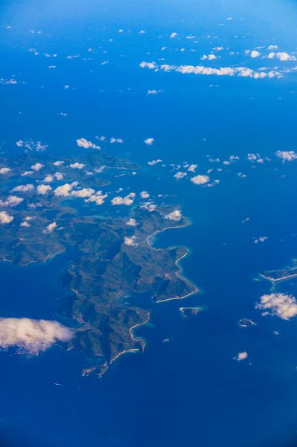 Stunning aerial view of islands surrounded by the vibrant blue ocean with scattered clouds. — Huizhou, Guangdong, China