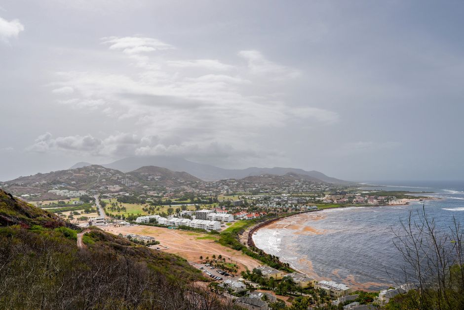 A stunning aerial view of the coastline in Saint Kitts, featuring lush hills and sprawling beaches. — Huizhou,