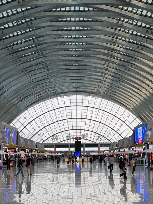 Spacious and futuristic interior of Tianjin Railway Station, bustling with travelers. — Huizhou, Guangdong, China