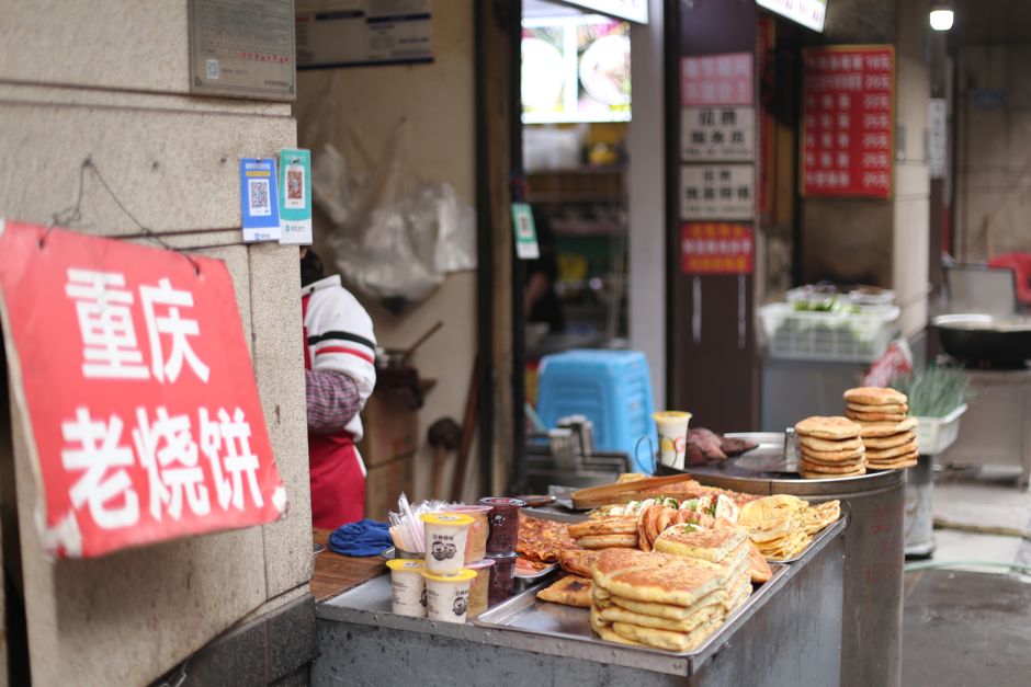 A bustling street food stall offering traditional Chinese pancakes in an urban setting. — Huizhou, Guangdong, China